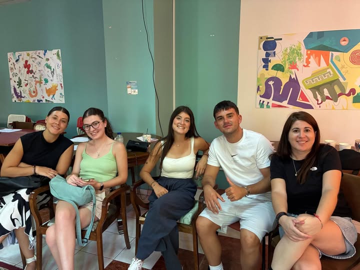 Puede ser una imagen de 5 personas, personas sonriendo, mesa y texto